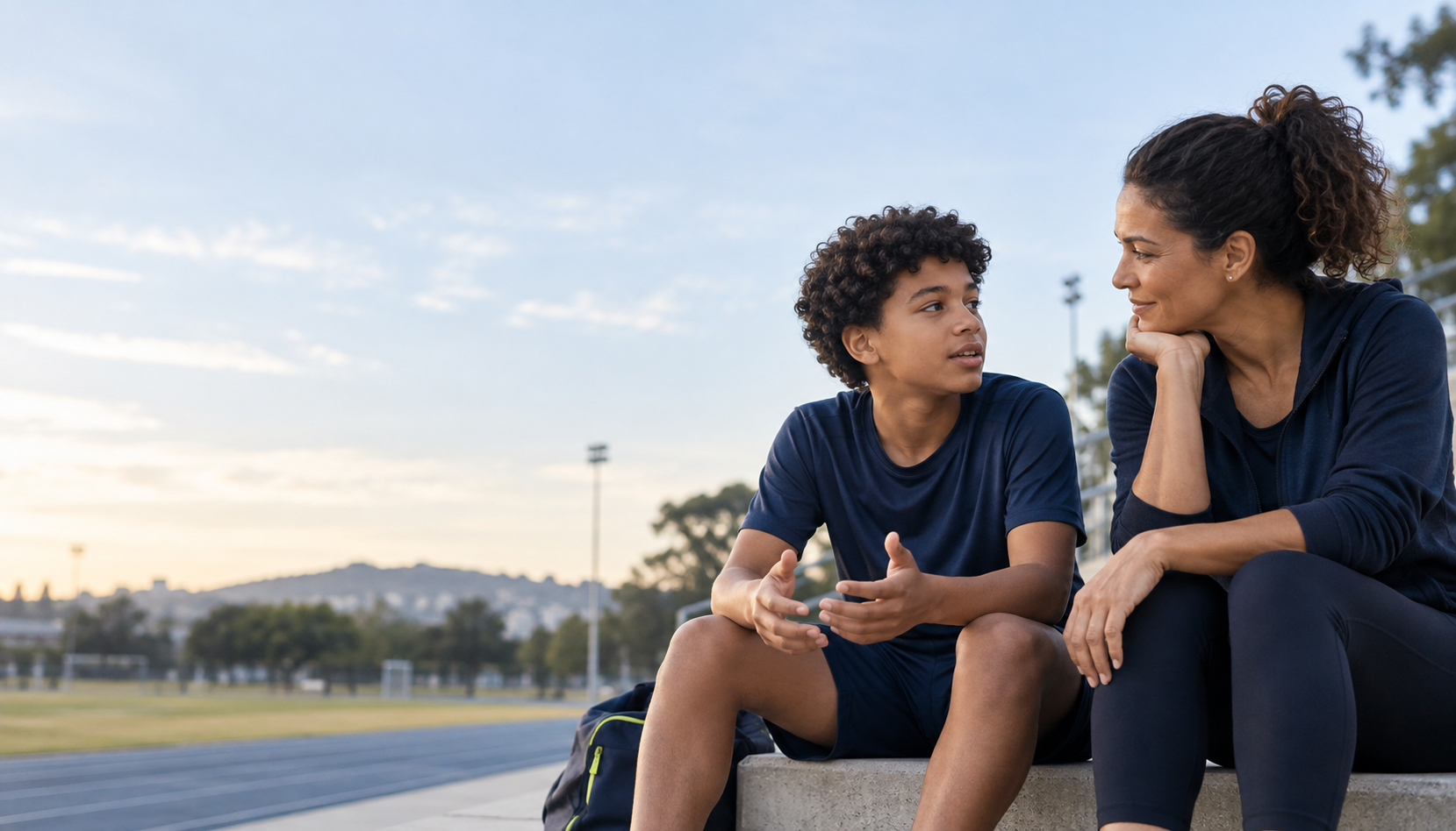 Mãe escutando seu filho atleta em uma conversa à beira da pista