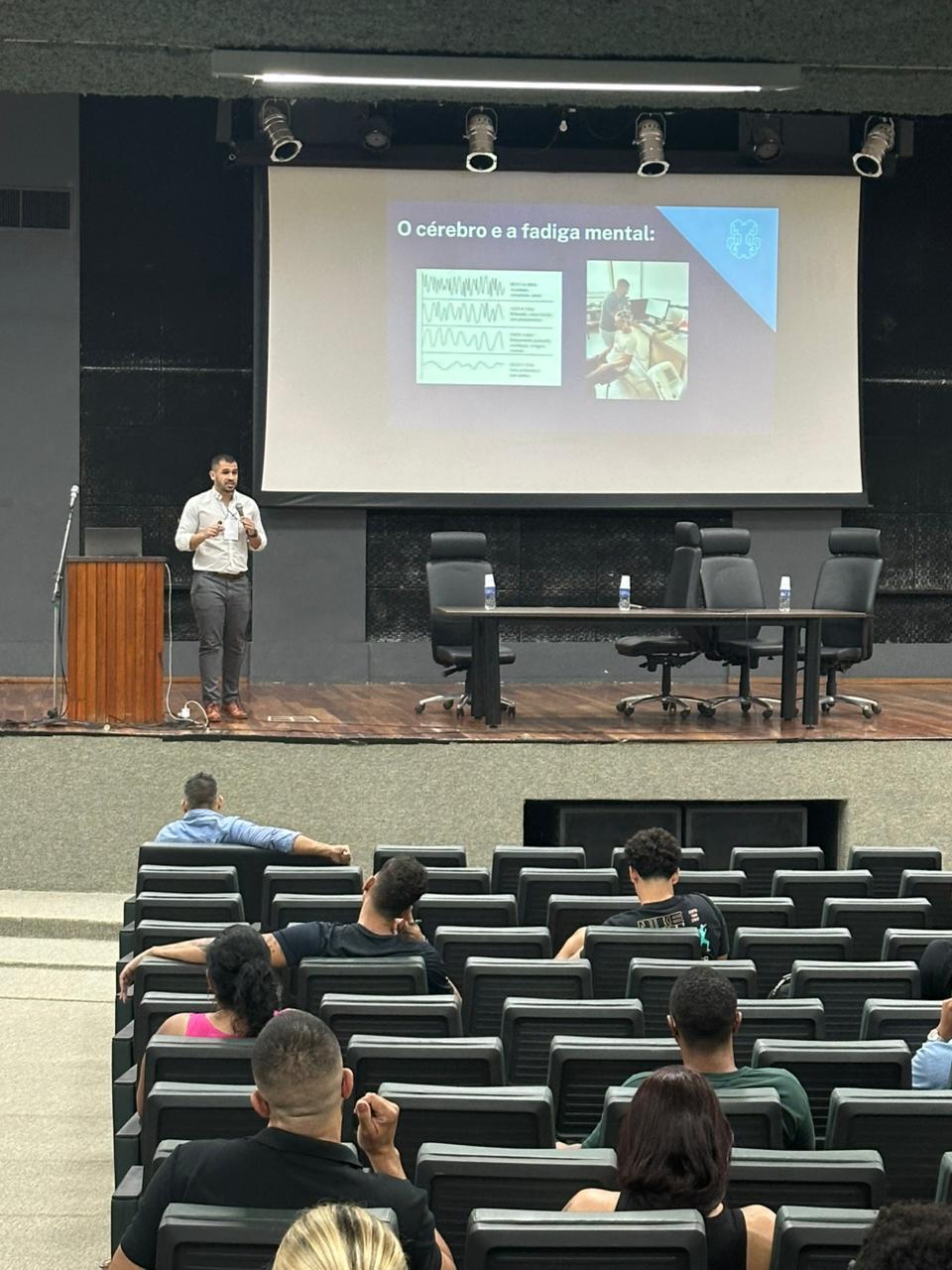 Everton Santana apresentando uma palestra sobre cérebro e fadiga mental em um auditório