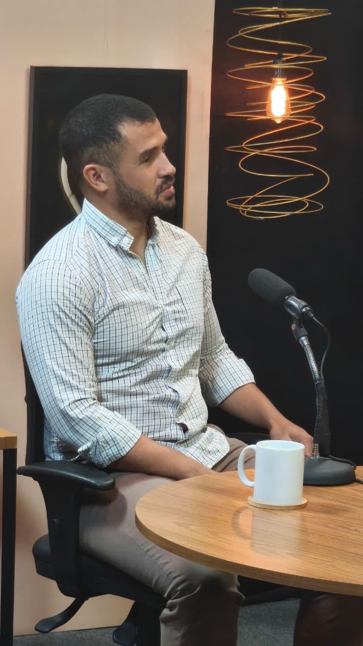 Everton Santana participando de uma conversa em estúdio com microfone